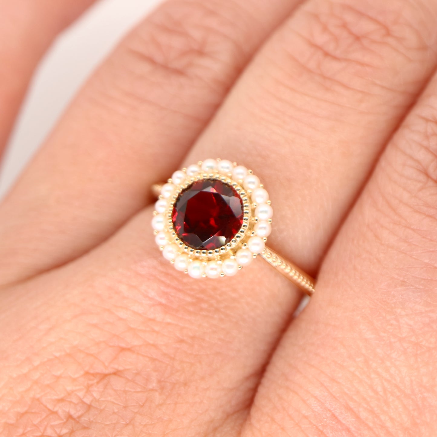 Colonial garnet filigree ring with pearl halo in yellow gold