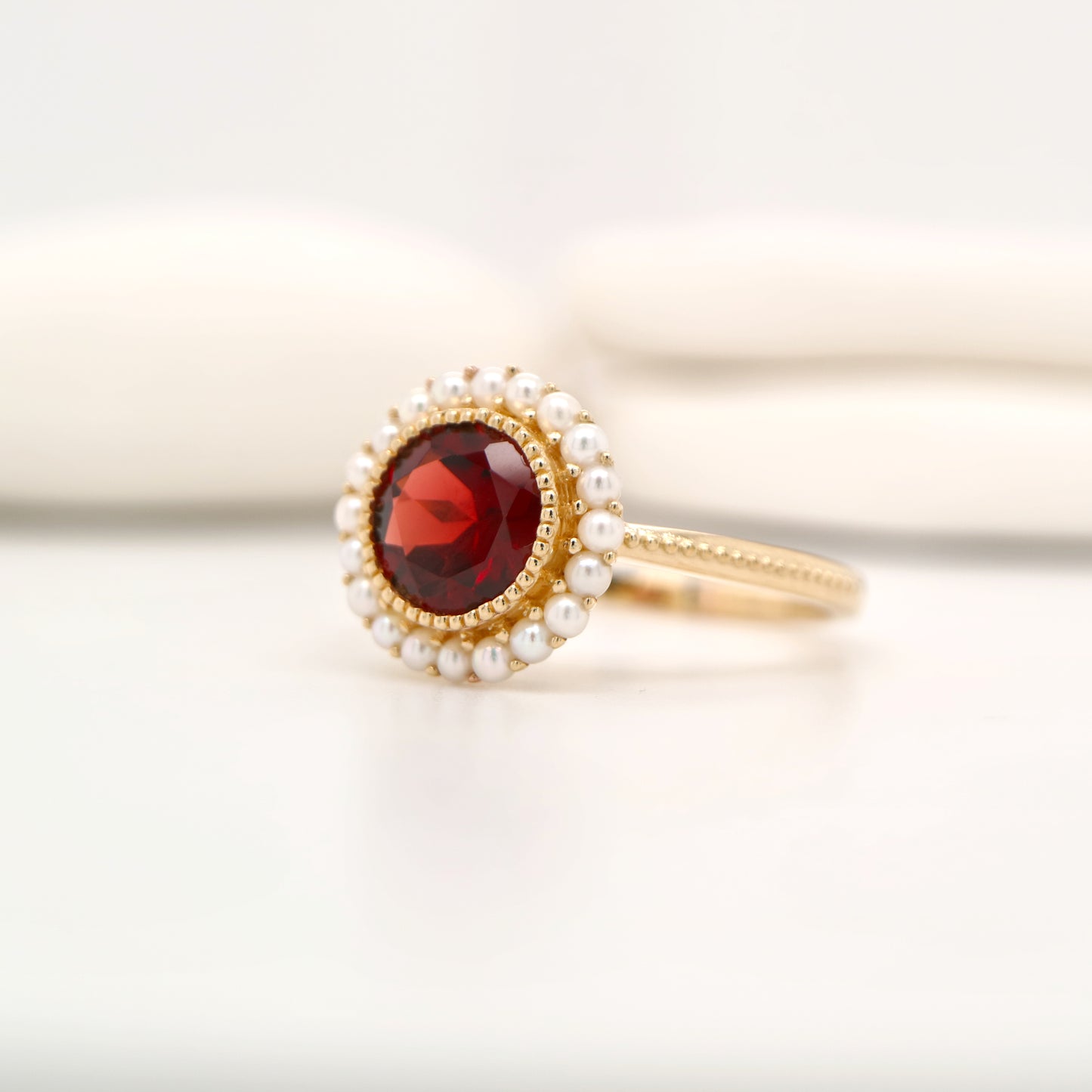 Colonial garnet filigree ring with pearl halo in yellow gold