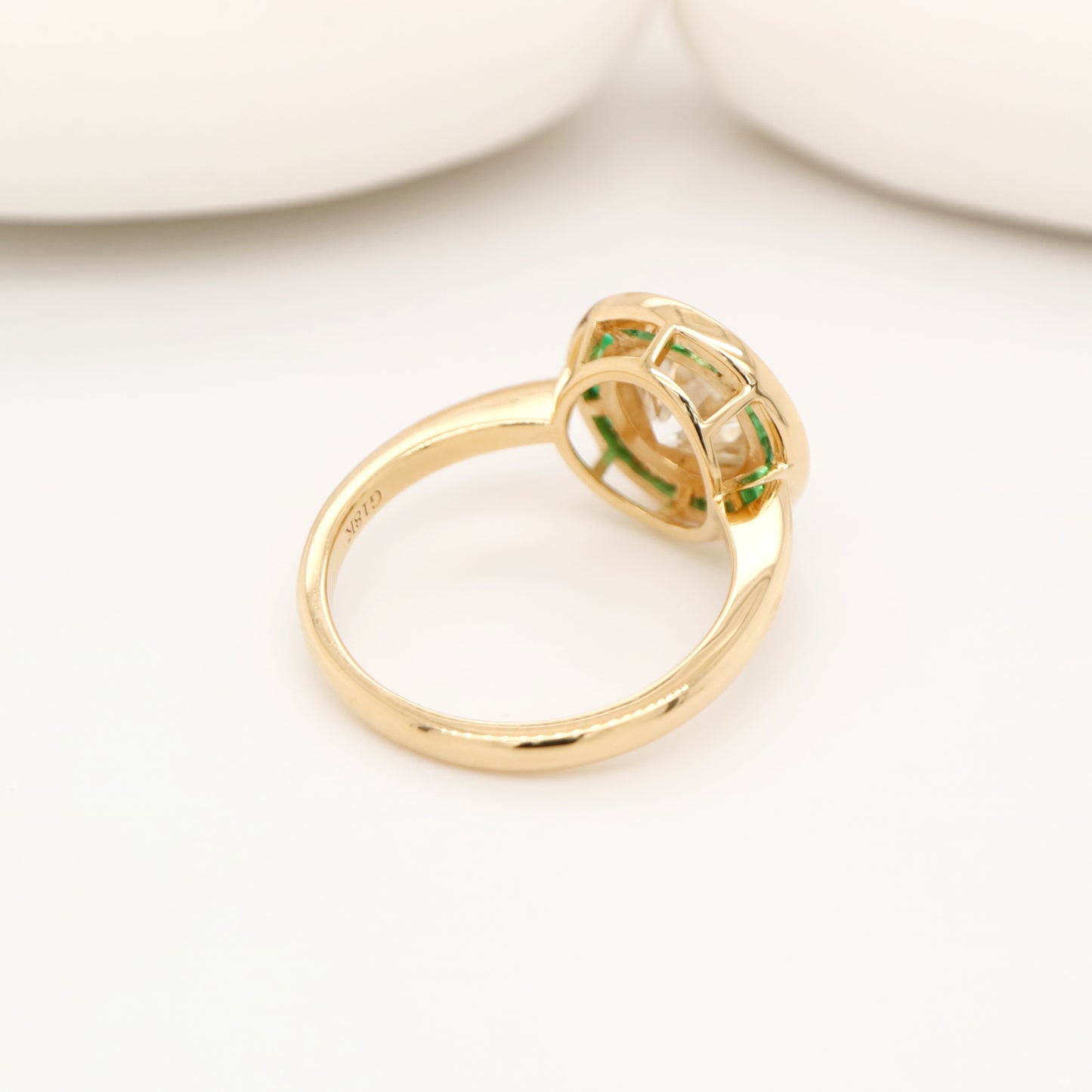 Moissanite with channel set emerald halo ring in yellow gold