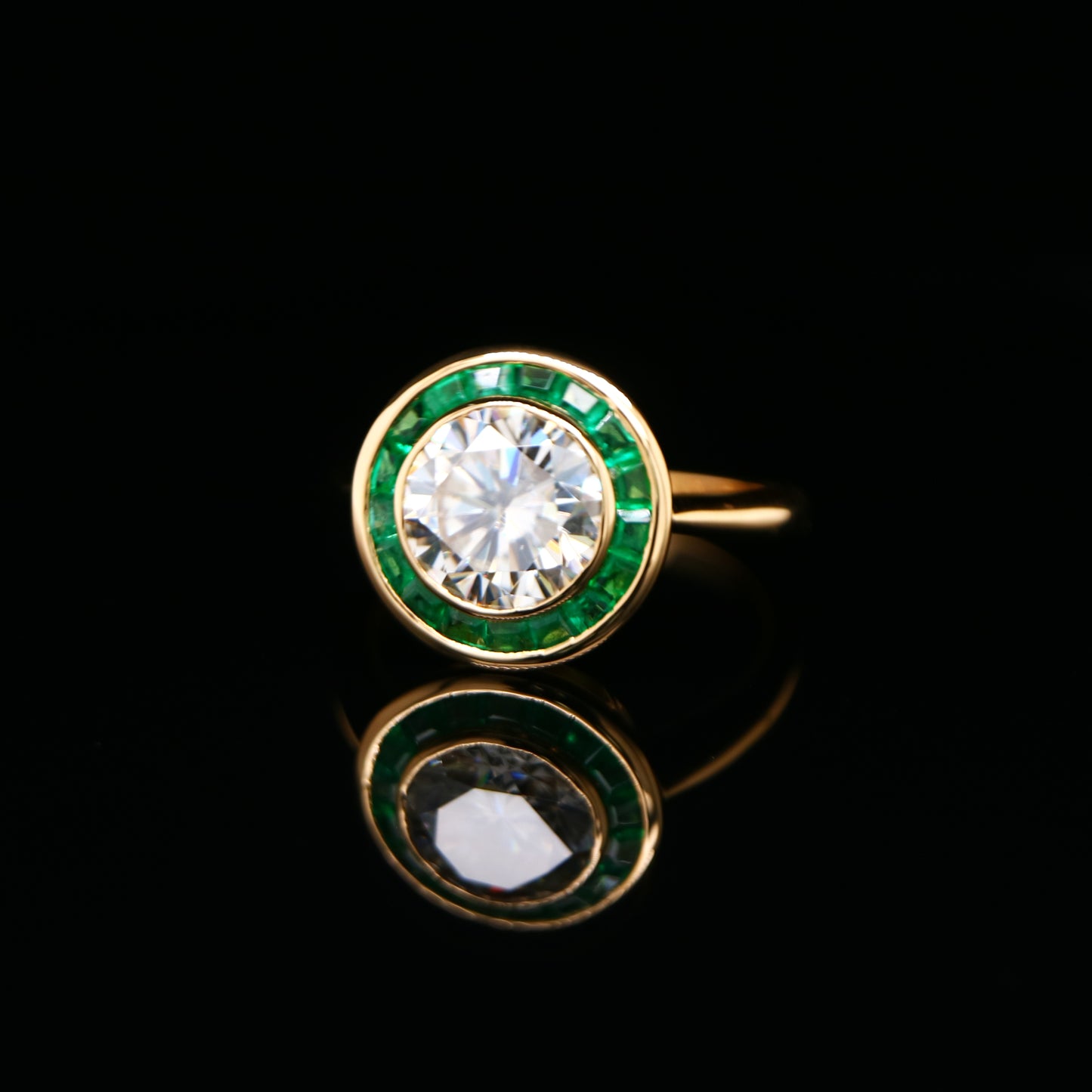 Moissanite with channel set emerald halo ring in yellow gold