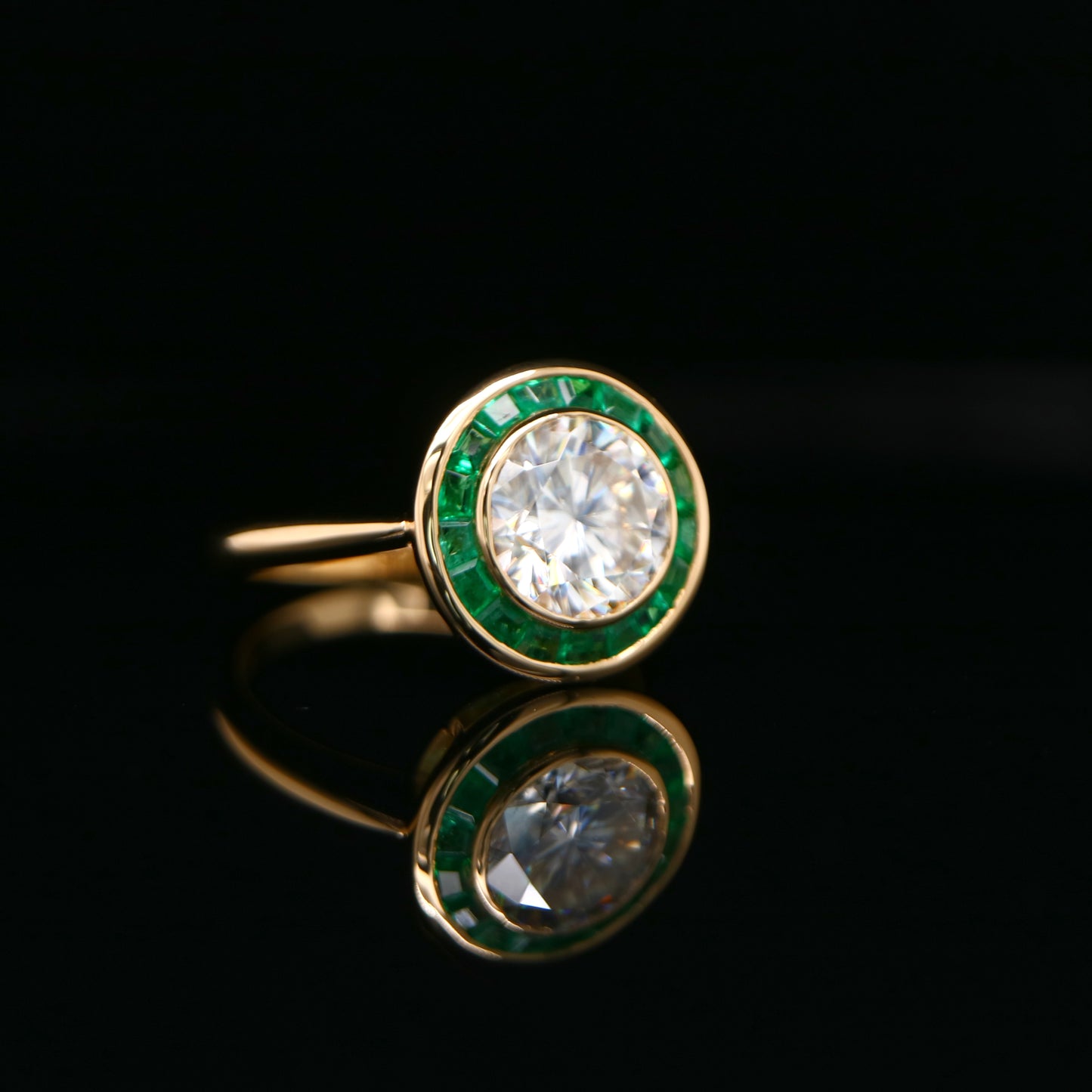 Moissanite with channel set emerald halo ring in yellow gold