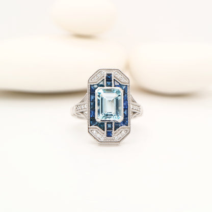 Art deco aquamarine cocktail ring with sapphire halo in white gold